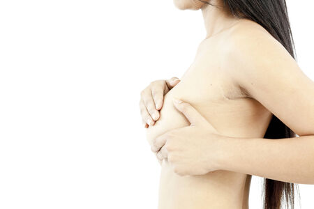 Side view of a woman covering her breastの写真素材