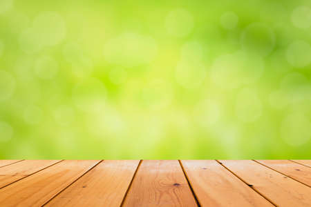 Wooden table with empty space. Has a green background, blurred and bokeh.の写真素材