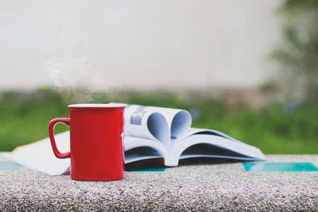 Heart shape in book and Cup of coffee on tableの写真素材