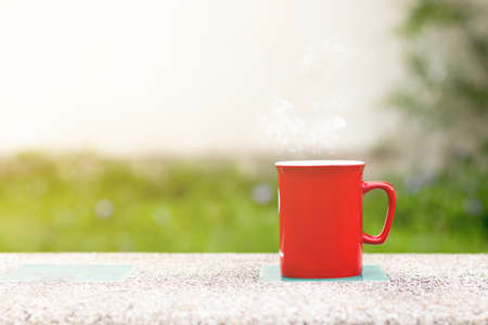 Coffee glass on the cement table. Grass is the backgroundの写真素材