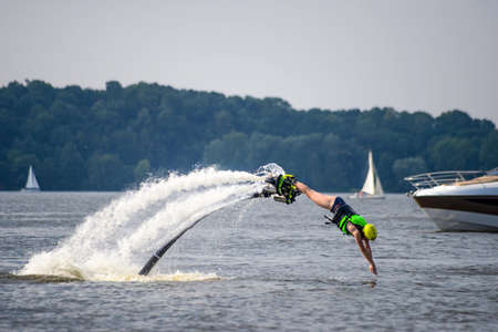 Young girl in jet boots is jumping into the lake - hydroflying.の写真素材