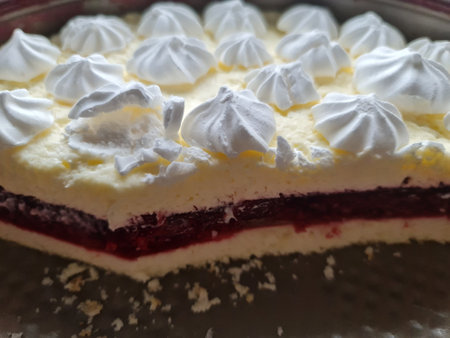 Closeup of a raspberry cake with whipped cream on a white plateの写真素材