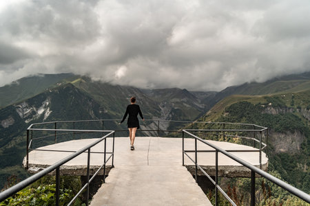Young woman walking on the top of the mountain in cloudy weather.の写真素材