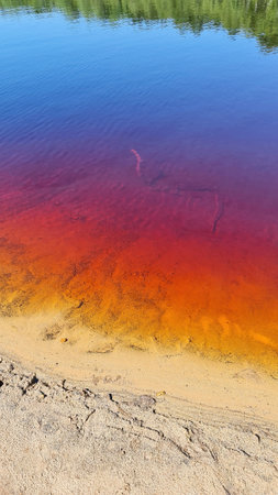 Red, yellow and blue, colorful waters of the lake in the Muskau Bend, the remins of the mining activity at the area.の写真素材