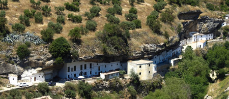 People have dinner under a huge hanging rock in Setenil de las Bodegas, Spainの写真素材
