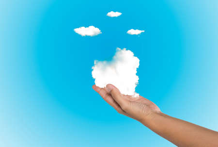 Cloud computing concept. Hand with blue sky and white cloud.の写真素材