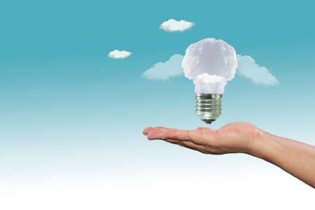 Lamp made of clouds in hand on sky. Ecology conception.Blue sky.の写真素材