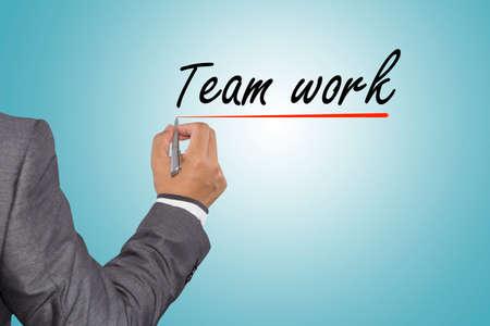 Team work concept, businessman hand writing Team work with pen on visual screen.の写真素材