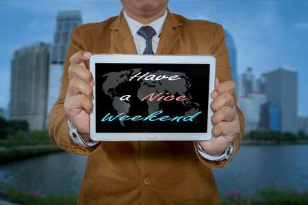Businessman holding tablet computer with Have a Nice Weekend on display.の写真素材