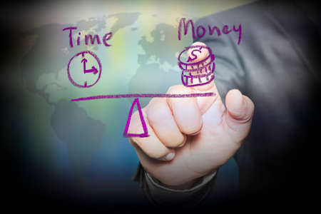 Businessman hand touching virtual screen a diagram with the balance of Scales in equal balance holding a clock left on the and money on the right.の写真素材