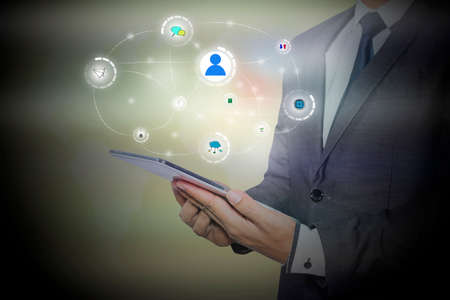 businessman holding a tablet PC with contact on virtual screens - business, technology, internet and social networking conceptの写真素材