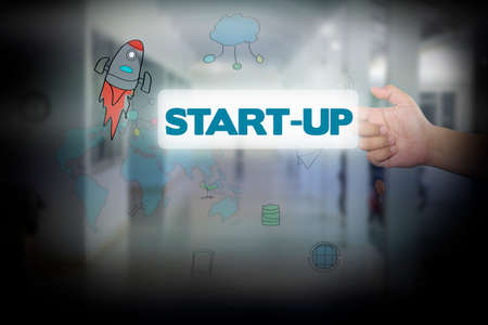 Hand pressing Start-Up on virtual screen. business concept.の写真素材