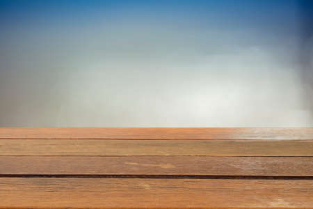 Wood table top on blurred blue sea background - used for display or montage your products. Vintage effect filter style picturesの写真素材