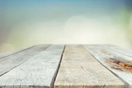 Wood table top on blurred blue sea background - used for display or montage your products. Vintage effect filter style picturesの写真素材
