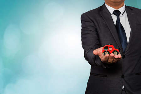 Businessman's hand holding toy carの写真素材