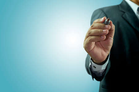 Businessman standing posture hand hold a pen isolated on over blue backgroundのeditorial素材