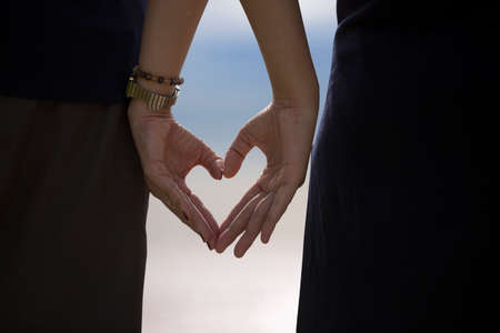 Two hands of lovers on the background of sunset on the seaのeditorial素材