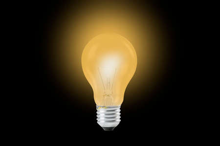 Glowing yellow light bulb, Realistic photo image turn on tungsten light bulb isolated on black backgroundの写真素材