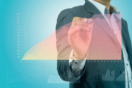 Businessman drawing graphics a growing graph over blue background