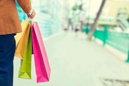 Happy shopping, male man hand holding shopping bags - Vintage Filterのeditorial素材