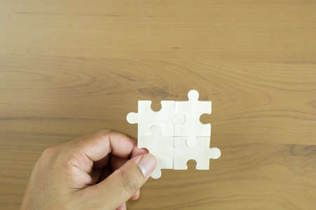 Hand holding piece of blank jigsaw puzzle