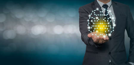 Young businessman holding  holding a brain hologram in hand,Brain representing creativity, innovation and similar with futuristic design.のeditorial素材