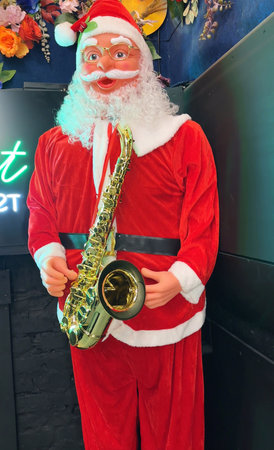 Unidentified santa claus playing saxophone at the Christmas fair in Bangkok, Thailand.の写真素材