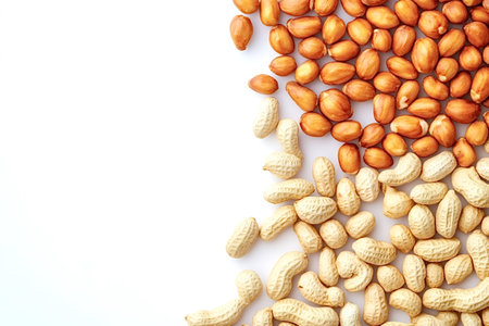 Shelled and unshelled peanuts are arranged on a white background, creating a visually appealing...