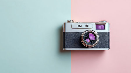 Retro styled camera displaying analogue hobby equipment on a split pastel pink and blue background, evoking design, creativity, and simple flat lay memoriesの写真素材