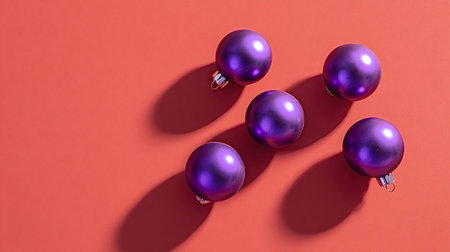 Purple matte christmas baubles arranged on a vibrant red background, casting long shadows, symbolizing holiday cheer and festive decoration with modern appealの写真素材