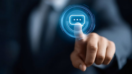 Business person's hand interacting with a glowing digital message bubble interface, symbolizing online communication, customer support, and global business networkingの写真素材