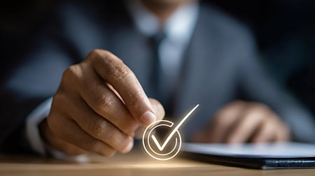 Businessman's hand selecting a glowing checkmark icon, representing approval, quality control, task completion, and success in a business context, indicating efficiency and verificationの写真素材