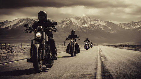 Group of motorcyclists rides choppers on an open road, heading towards snow capped mountains under a dramatic sky, evoking concepts of freedom, road trips, and adventure in sepia tonesの写真素材