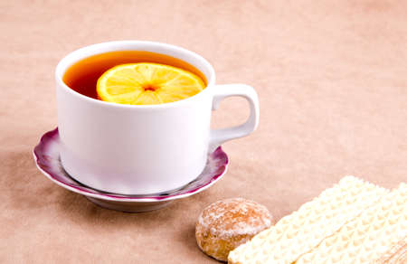 Tea with Lemon and sweet treats on the background of suedeの写真素材