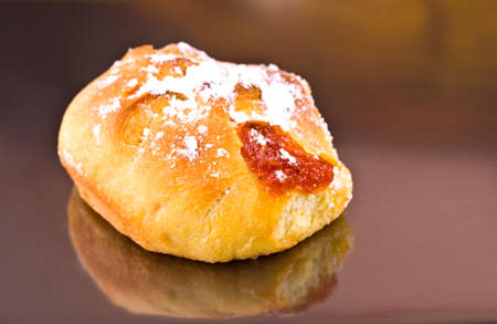 Bun with jam on a gray background with reflection