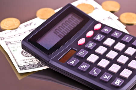 Money, coins and the calculator on a gray background from aluminum