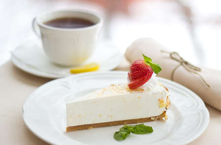souffle cake with strawberries and a cup of tea on tableの写真素材