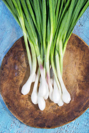 Green onions on a wooden shabby backgroundの写真素材