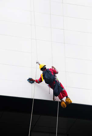 Industrial mountaineering workers wash windows of a high-rise buildingの写真素材