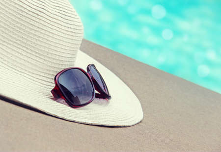 Straw hat, glasses by the poolの写真素材
