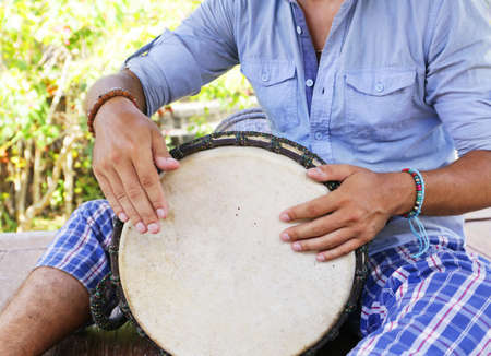 man playing on djembe
