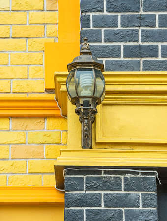 Black lantern of metal at a wall outside the house.の写真素材