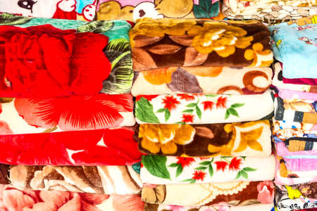 A stack of neatly folded colored blankets.の写真素材
