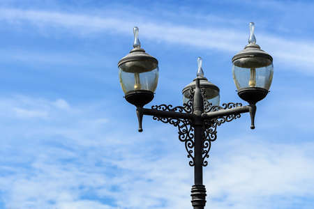vintage lighting pole with twin double lamp lantern on background of blue sky.の写真素材