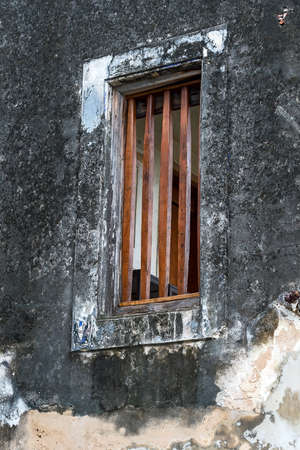 Romantic old house with a wooden window and lots of vegetation.