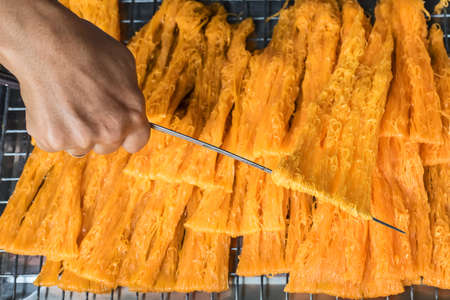 Hand are making of Thai dessert, Foi Thong or Golden Egg strips (or Fios de ovos in Portuguese), one of the most famous Thai dessert. Selective focus.の写真素材
