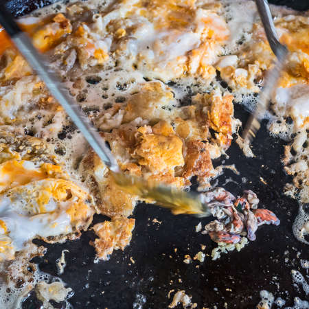 Fried clams.Thai food.Pan-fried crispy mussel with bean sprout.Crispy Fried mussel, flour and egg with spade of frying pan.Popular Thai Cuisine. Delicious food on the sidewalk.の写真素材