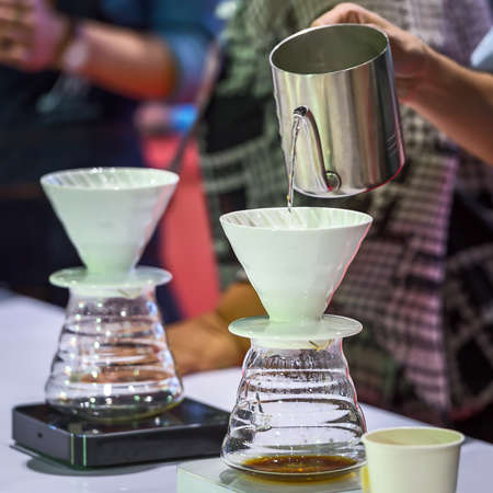 Hand drip coffee , Barista pouring water on coffee ground with filter.の写真素材