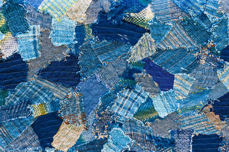 Ripped denim patch on destroyed torn denim blue jeans. Double color denim jeans fashion background.
