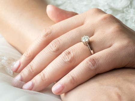 Close up of hands of asian woman showing the ring with diamond. Meaning she is engaged.の写真素材